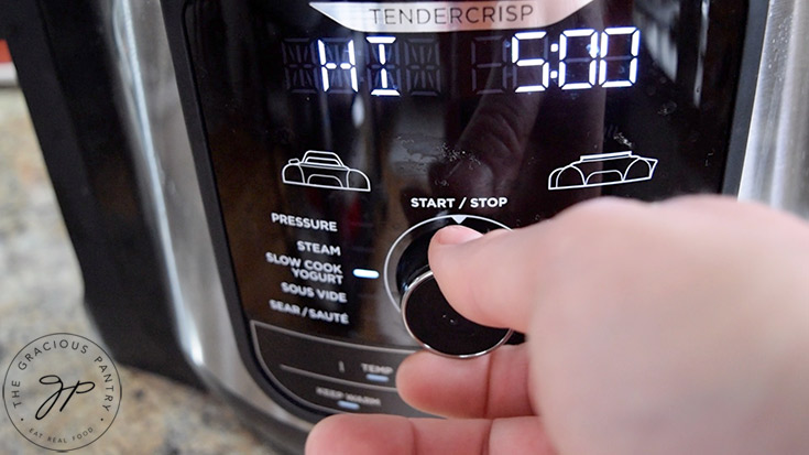 Setting time and temperature on a slow cooker to cook the chicken curry soup.