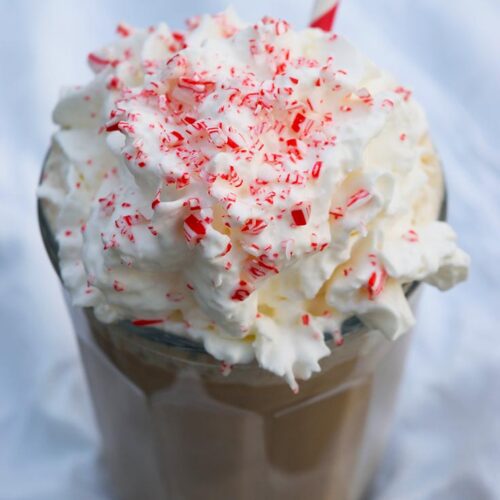 A side view of a Homemade Peppermint Mocha topped with whipped cream and crushed candy cane.