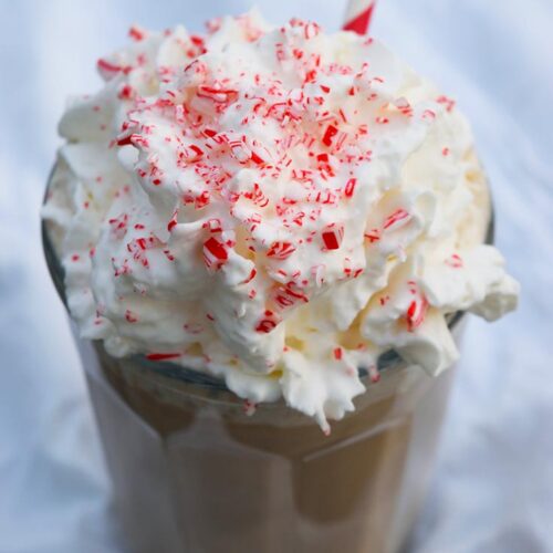 A side view of a Homemade Peppermint Mocha topped with whipped cream and crushed candy cane.
