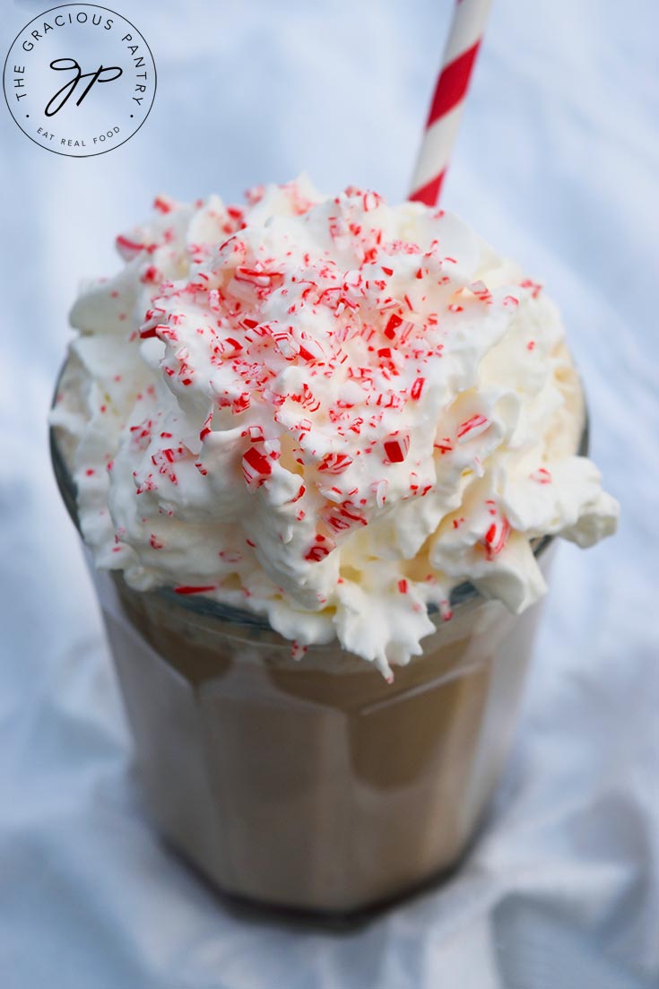 A side view of a Homemade Peppermint Mocha topped with whipped cream and crushed candy cane.