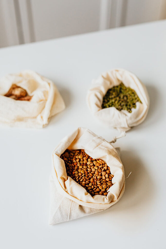 Three muslin bags holding three different types of lentils.