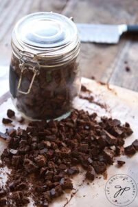 Mint Chocolate Chips on a cutting board and in a glass storage jar.