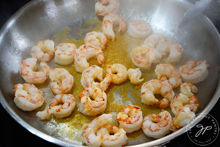 Shrimp cooking in a skillet.