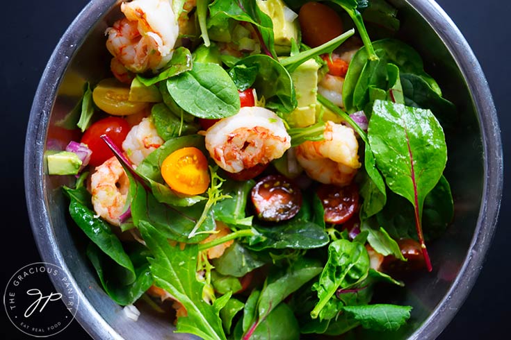 The shrimp and avocado salad mixed with kale and greens.