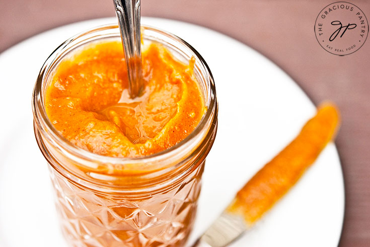 An angled view into a small glass jar filled with Sweet Potato Butter.