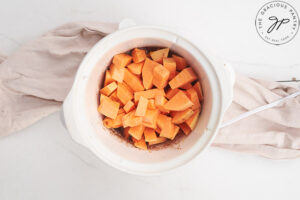 Sweet Potato Butter Recipe ingredients sitting in a small, white slow cooker.