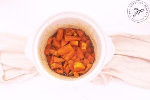 Sweet Potato Butter Recipe ingredients cooked, and still sitting in a small, white, slow cooker.