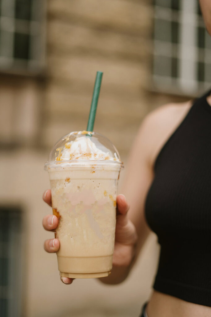 A female hand holds a blended coffee drink.