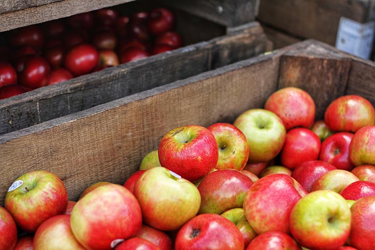This list of superfoods includes apples. This image shows apples in a wood crate.