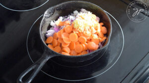 Onions, carrots and ginger sautéing in a skillet.