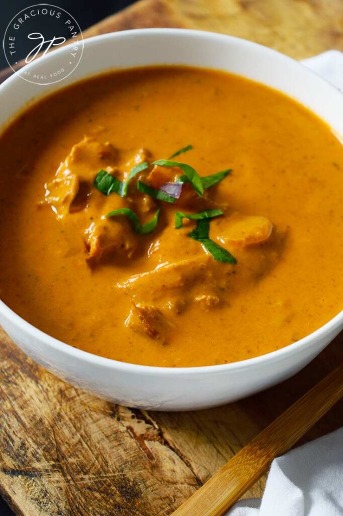 A close up of a white bowl filled with butter chicken.