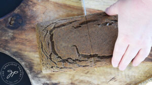 Cutting a loaf of chicken bread in half.