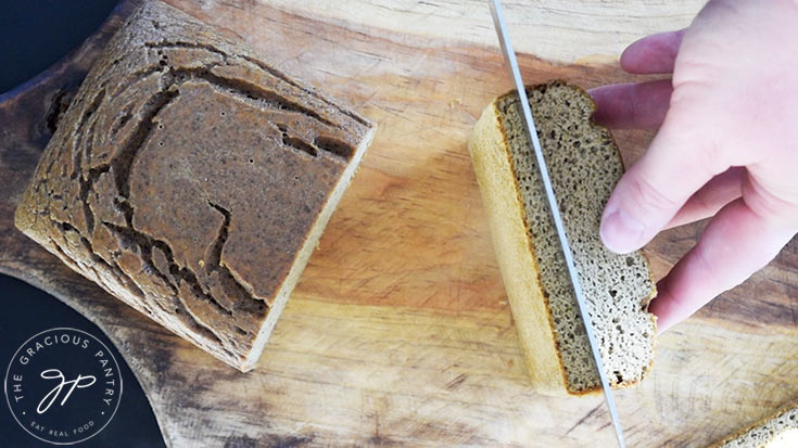 Cutting half of the Chicken Bread loaf into three slices.