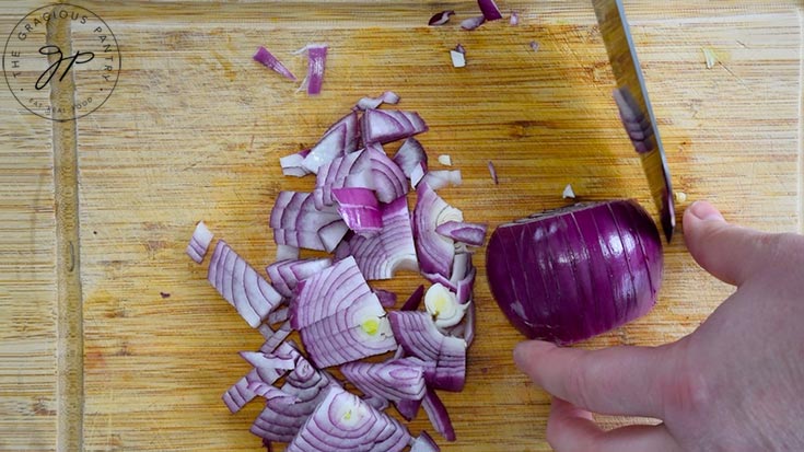 Chopping a purple onion.