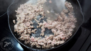 Browning ground meat in a skillet.