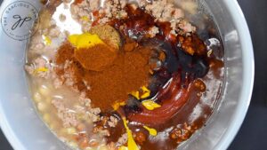 Yellow mustard, smoked paprika and balsamic vinegar added to beans in a crock.