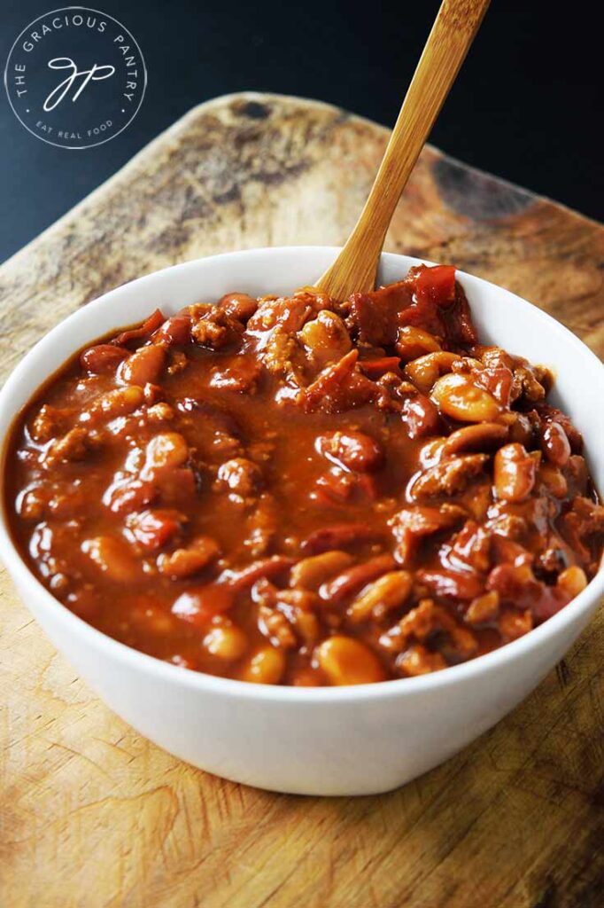 A frontal view of a white bowl filled with Slow Cooker Cowboy Beans.