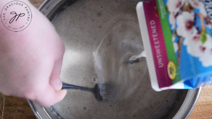 Whisking extra milk into a pot of just-made French vanilla coffee creamer.