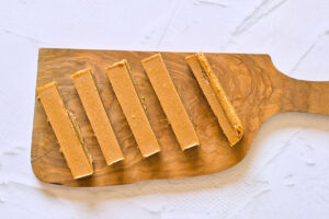 Cut Healthy Twix Bars without chocolate coating laying on a cutting board.