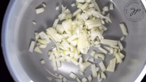 Chopped onions sitting in a slow cooker.