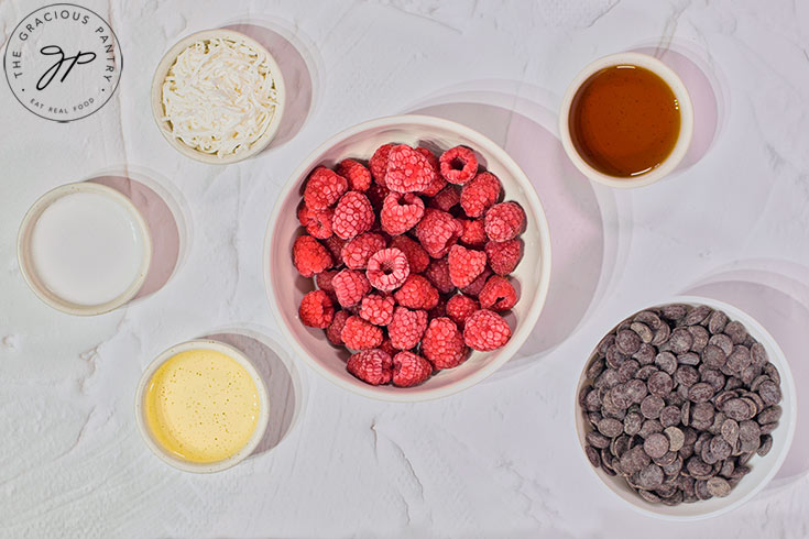 Raspberry Coconut Truffles recipe ingredients in individaul, white bowls on a white surface.