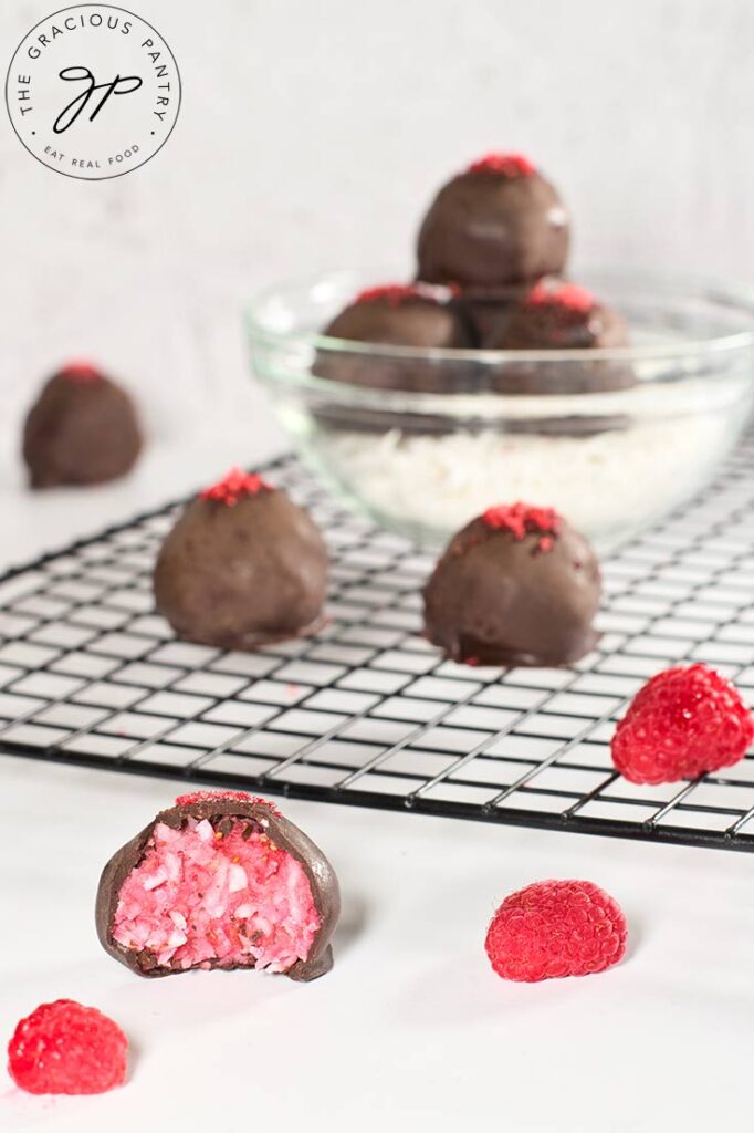 A close up of a Raspberry Coconut Truffle with a bite removed.