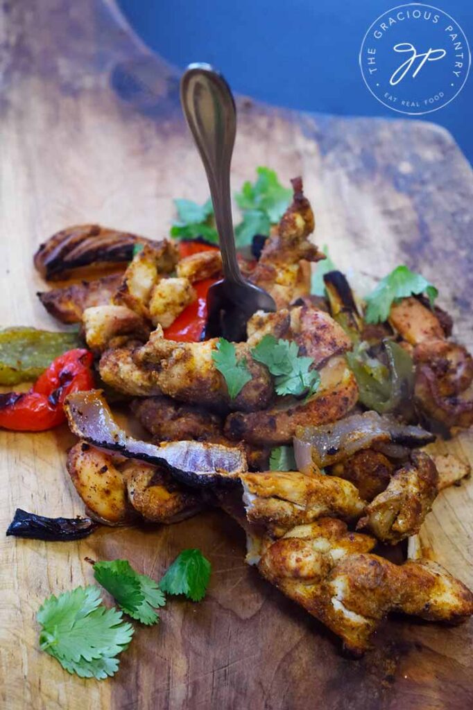 Finished Sheet Pan Fajitas on a cutting board.