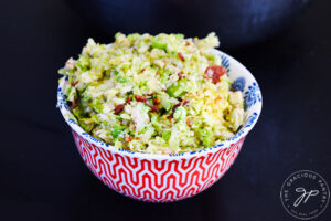 A single, decorative bowl on a black background, is filled with Brussels Sprouts Salad.