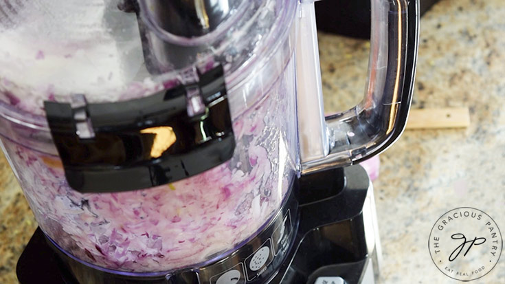 Grating onions in a food processor.