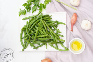 Garlicky Green Beans Recipe ingredients gathered on a white surface.