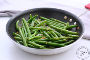 A skillet holds Garlicky Green Beans.