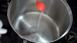 Adding oil to a soup pot.
