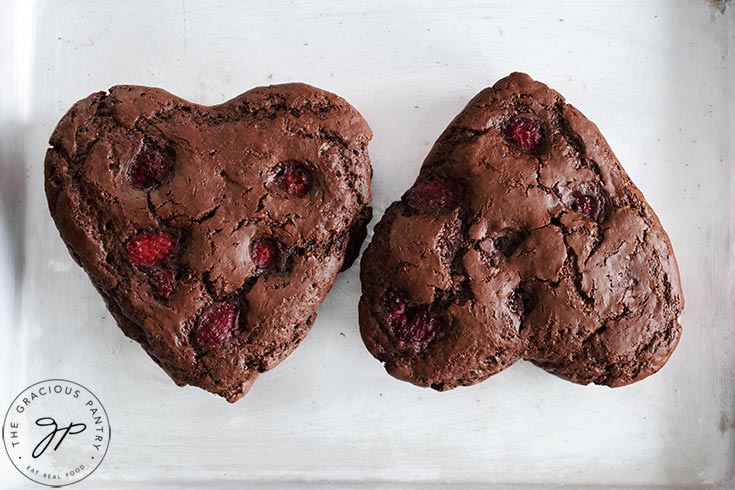 Two just-baked Healthy Chocolate Raspberry Cakes sitting on a sheet pan.