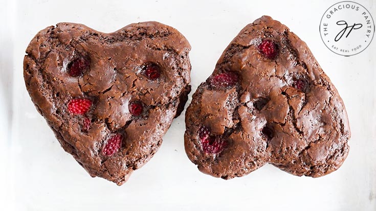Two just-baked Healthy Chocolate Raspberry Cakes on a baking pan, fresh out of the oven.