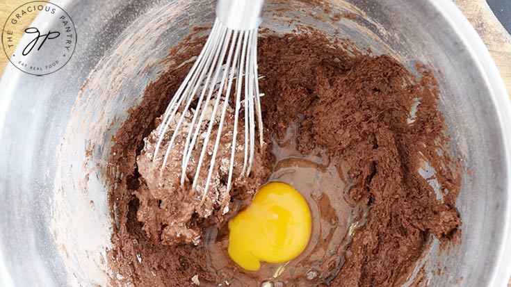 An egg added to the Healthy Chocolate Raspberry Cake batter.