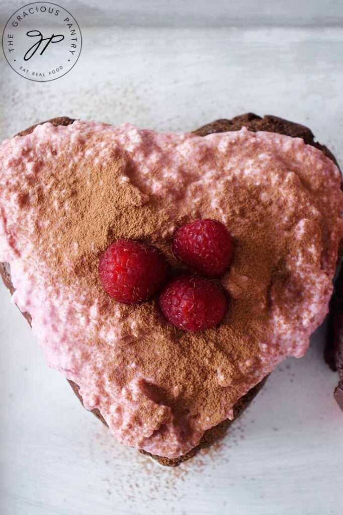 A single frosted and garnished Healthy Chocolate Raspberry Cake.
