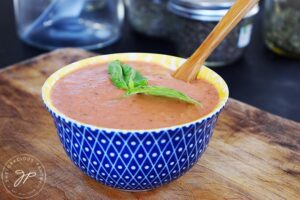 A blue and yellow bowl filled with Healthy Tomato Soup.