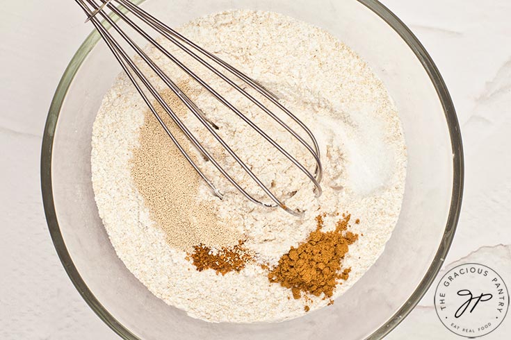 Dry ingredients sitting in a mixing bowl with a whisk.