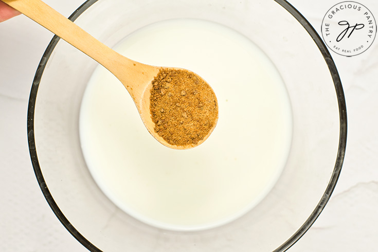 Adding sweetener to milk in a mixing bowl.