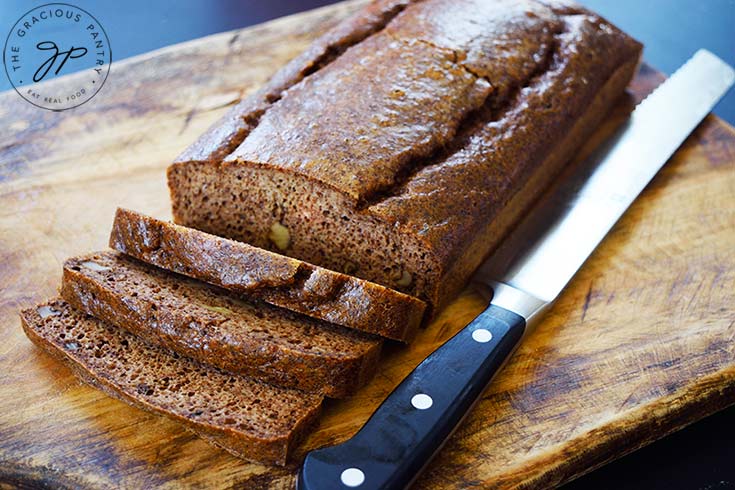 Partially sliced Pecan Butter Bread sitting on a cutting board.