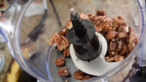 Pecans sitting in a food processor.