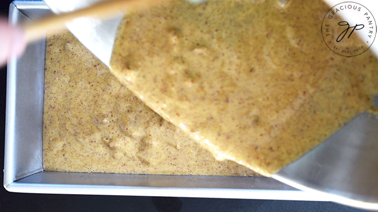 Pouring Pecan Butter Bread batter into an oiled loaf pan.