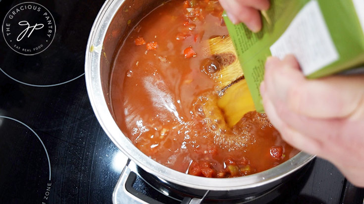 Adding broth to the Ranch Style Beans base.