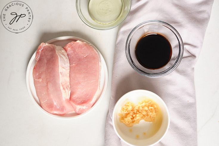 Balsamic Pork Chops Recipe ingredients in individual bowls on a white surface.