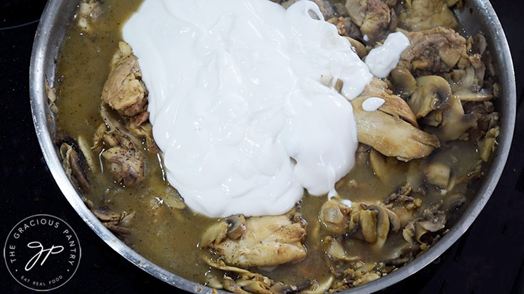 Adding plain yogurt to a skillet.