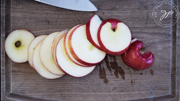 Cut apple slices laying on a cutting board.