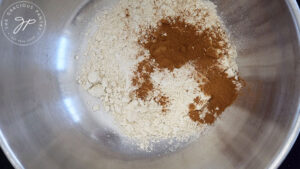 Flour, salt and ground cinnamon in a mixing bowl, unmixed.