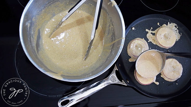 Filling in the apple centers with batter as they cook.