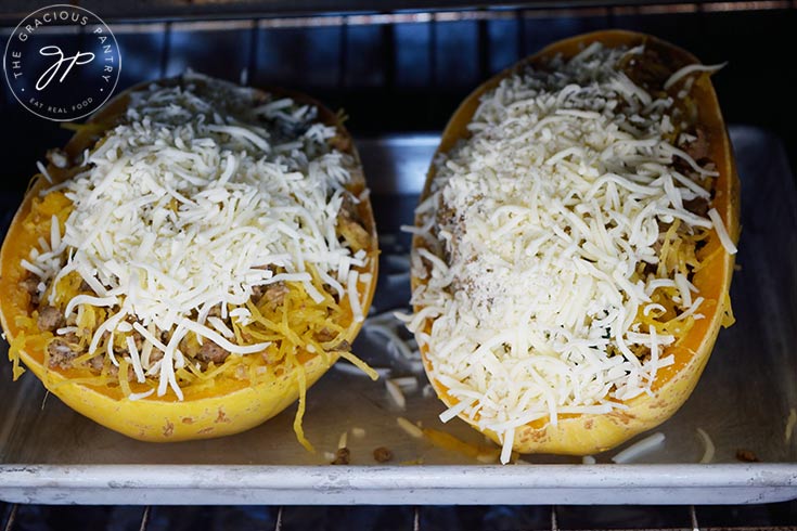 Two Italian Spaghetti Squash Boats sitting on a baking pan in an oven.