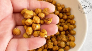 A hand holds air-fried chickpeas.
